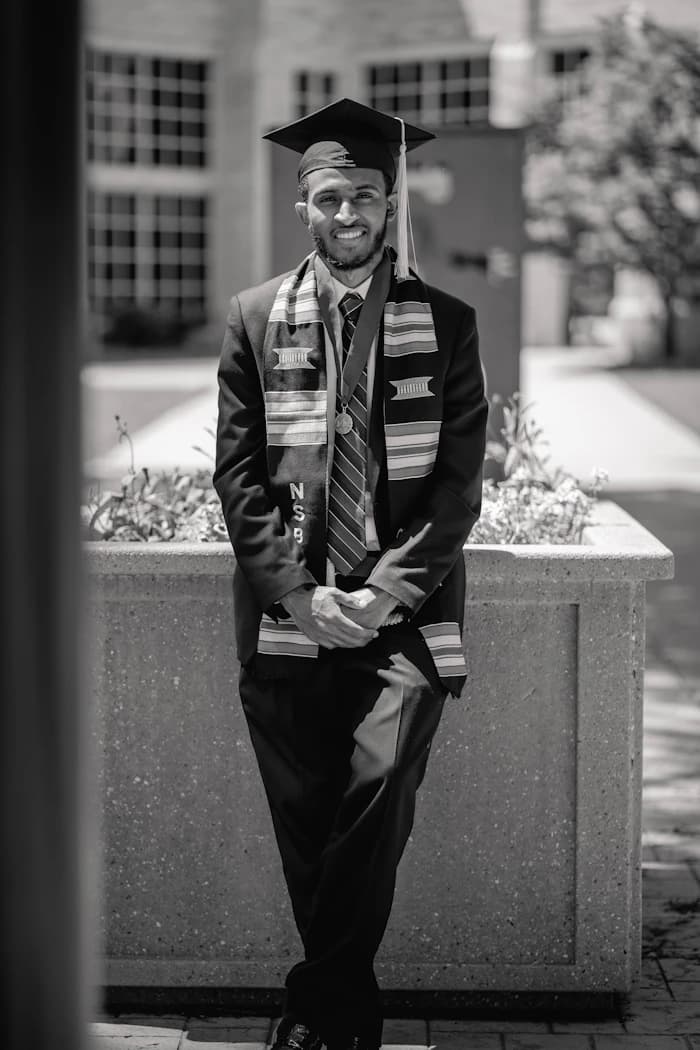 Graduate in a cap and gown, photographed in black and white